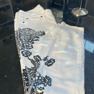 Bebe women’s white Jeans with black lace stenciling down the legs